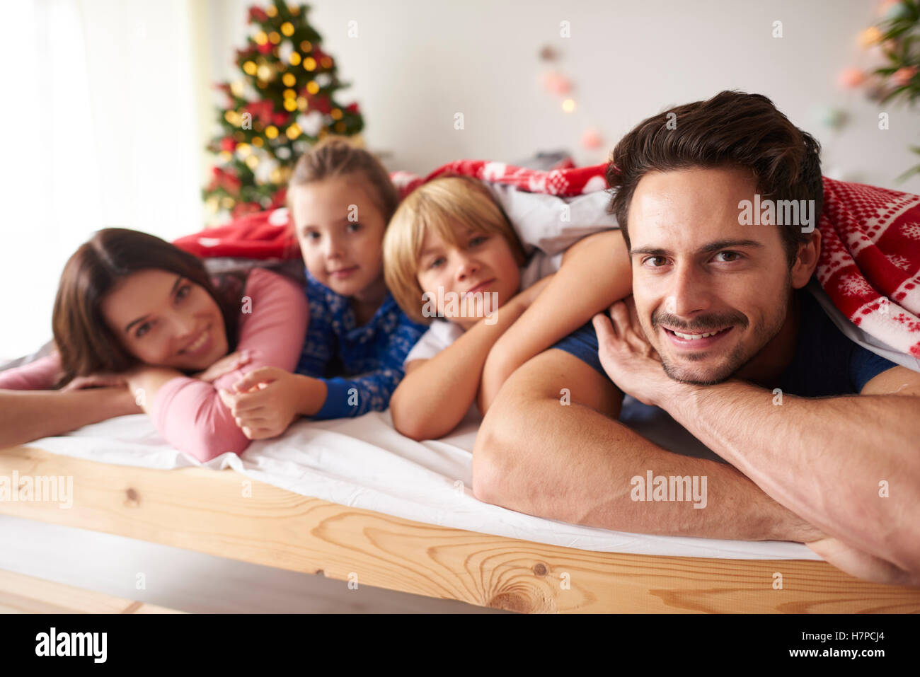 Familie in der Weihnachtszeit im Bett liegend Stockfoto