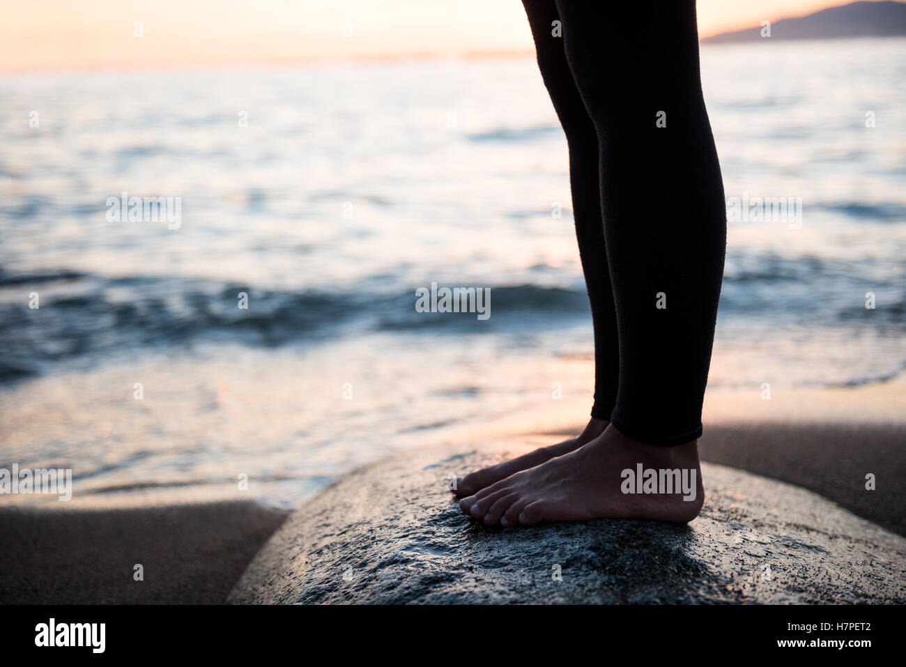Nahaufnahme von Frau Bein während der Durchführung von Yoga auf Felsen Stockfoto