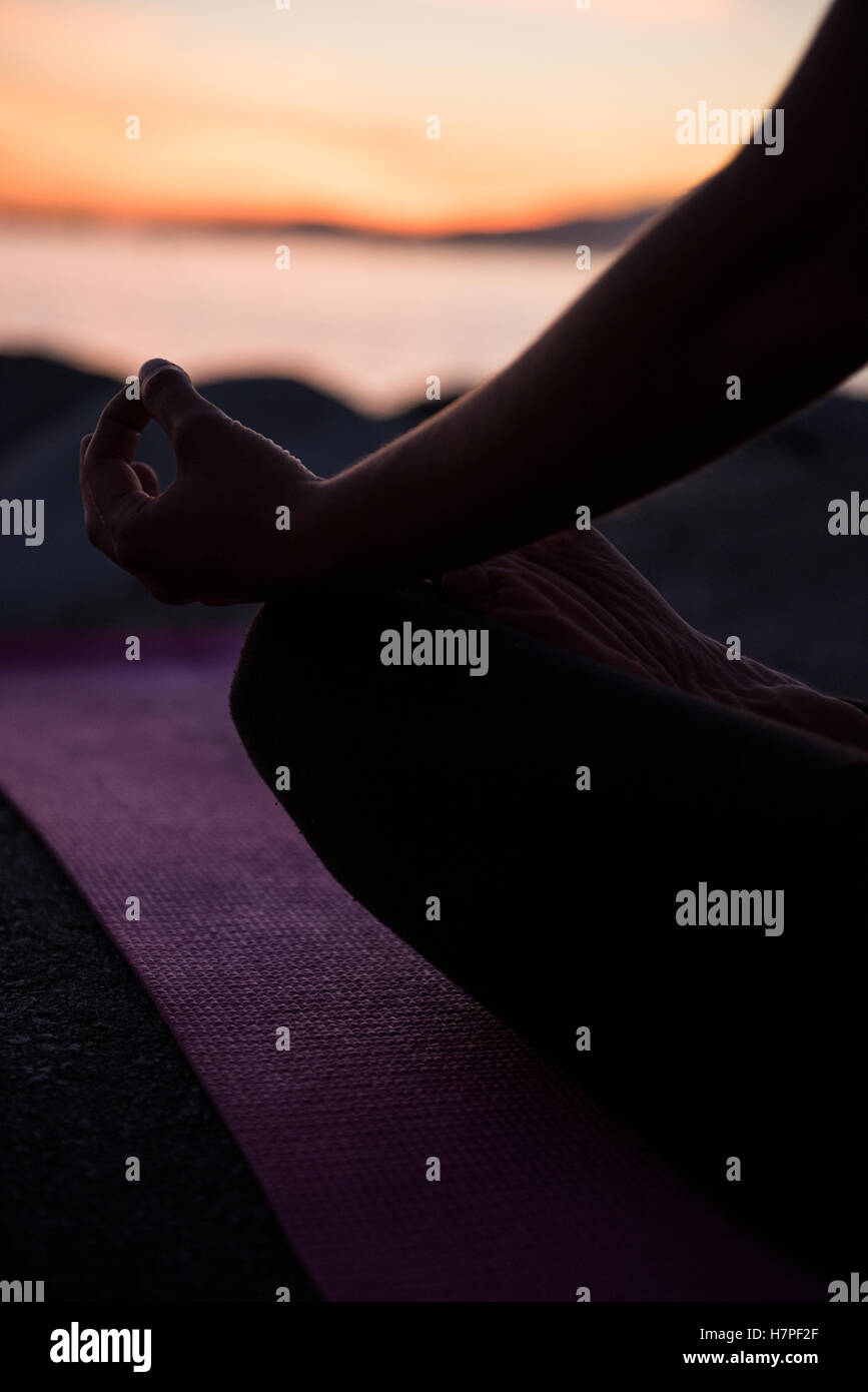 Mittleren Bereich der Frau, die Durchführung von Yoga am Strand Stockfoto