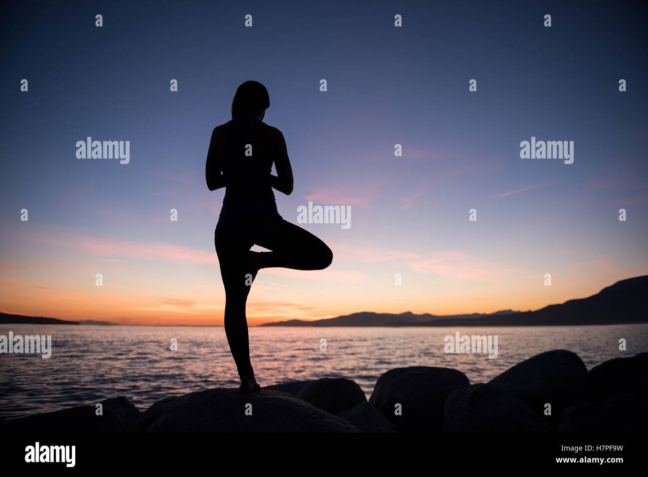Frau, die Durchführung von Yoga auf Felsen Stockfoto