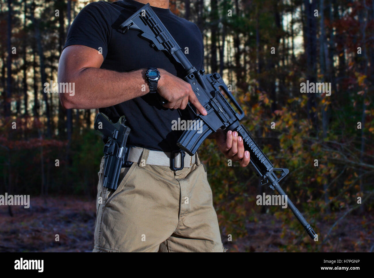 Mann mit einer Waffe und Ar-15, das ist auf der Hut im Wald Stockfoto