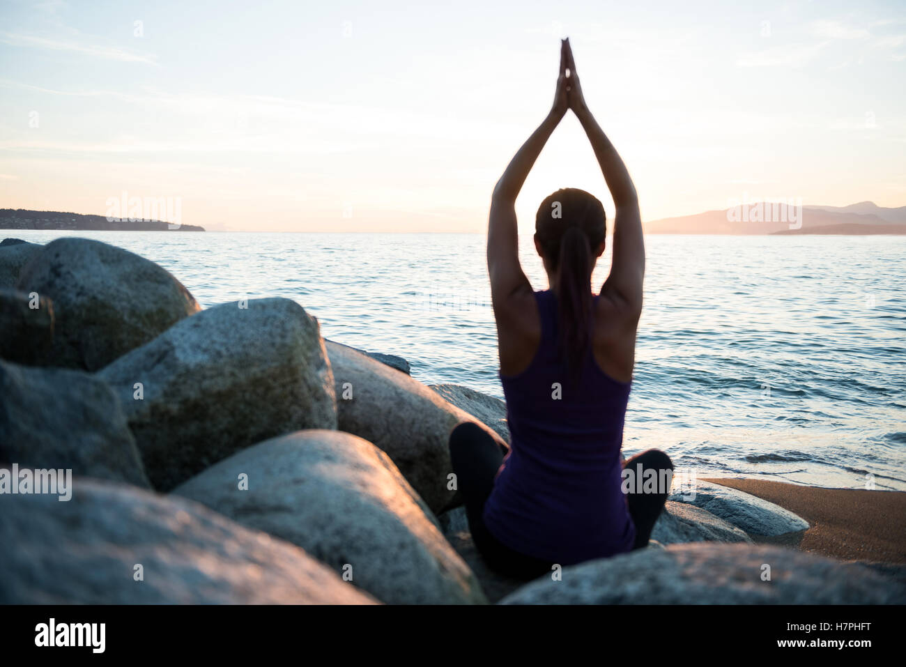 Rückansicht der Frau, die Durchführung von Yoga auf Felsen Stockfoto