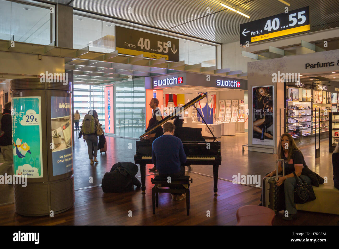 Ein Passagier eine öffentliche Stutzflügel Klavier in den Abfahrten-Halle Flughafen Toulouse, Blagnac, Haute-Garonne, Occitanie, Frankreich Stockfoto