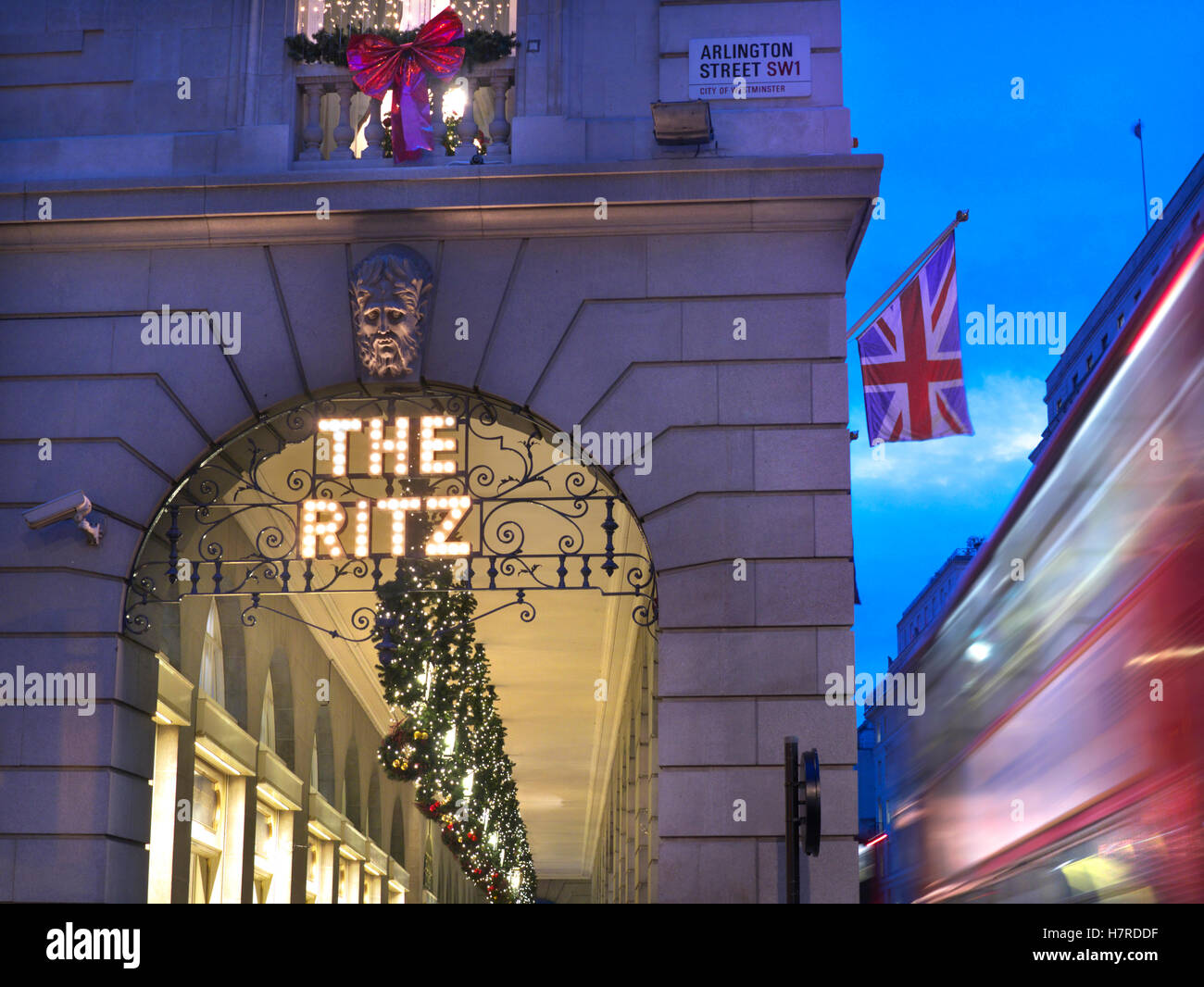 LONDON WEIHNACHTEN BLUR BUS das Ritz Hotel in der Dämmerung mit Weihnachtsschmuck Union Jack Flagge und verschwommenes vorbei an traditionellen roten Bus Piccadilly London UK Stockfoto