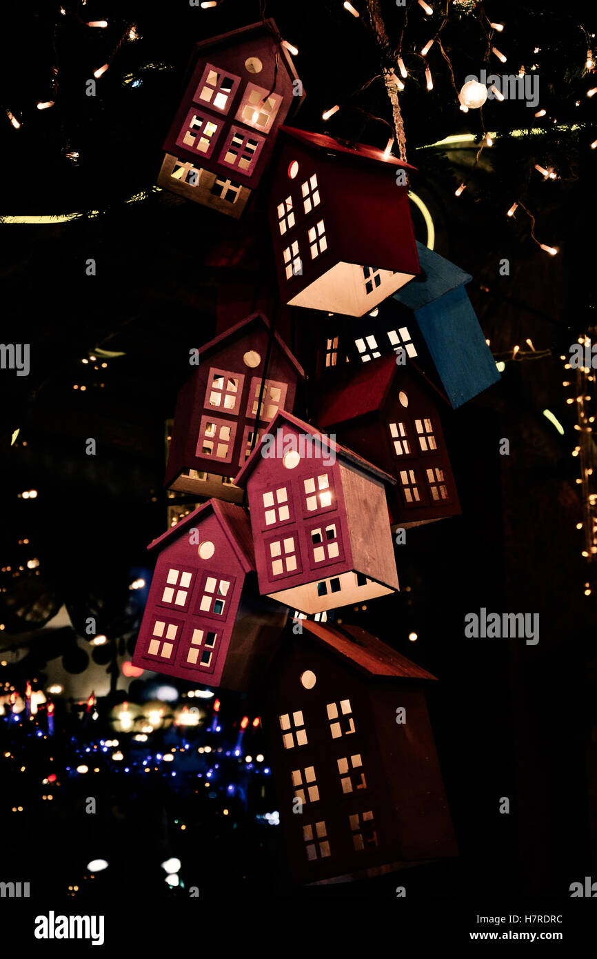 Leuchtende Spielzeug Häuser am Weihnachtsbaum im Dunkeln Stockfoto
