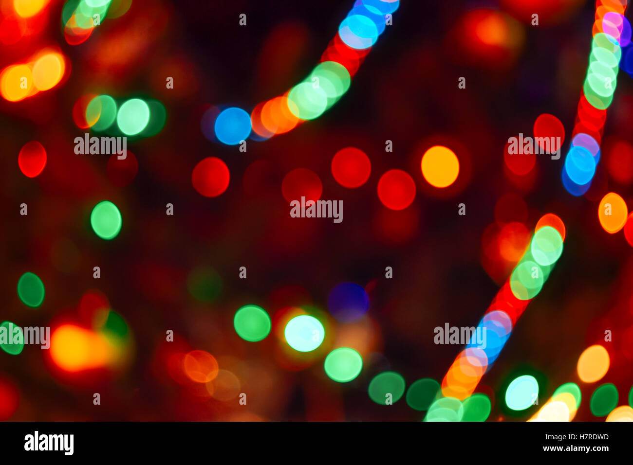 Christmas Lights Hintergrund. Verschwommene elektrische Girlande am Weihnachtsbaum. Rot, grün, gelb, orange und blau leuchten Stockfoto