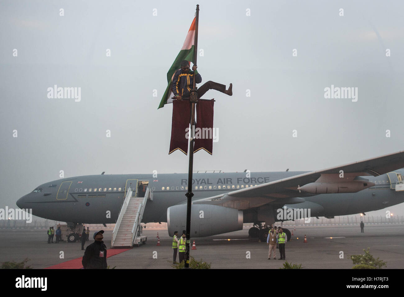 Ein Flughafen-Mitarbeiter setzt sich die indische Flagge am Flughafen Indira Gandhi in Neu-Delhi, bevor Ministerpräsident Theresa Mai nach Bangalore am letzten Tag einer dreitägigen Handel-Mission entwickelt flog, um den Weg für enge Handelsbeziehungen mit den asiatischen Riesen nach Austritt zu ebnen. Stockfoto