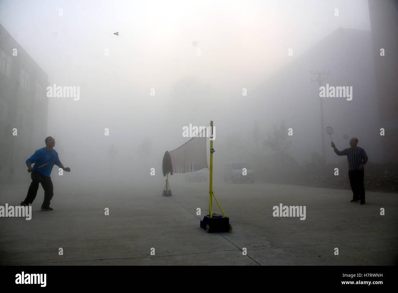 Liaocheng, Liaocheng, China. 5. November 2016. Liaocheng, CHINA-November 5 2016: (nur zur redaktionellen Verwendung. CHINA HERAUS). Zwei Männer spielen Badminton in smoggy Tag in Liaocheng, Ost-China Shandong, 5. November 2016. Das nationale meteorologische Zentrum CMA veröffentlicht eine orange Warnung von Smog am 4. November 2016, zeigt, dass schwere Dunst zentrale, nordwestlichen und nördliche Regionen Chinas hüllt. © SIPA Asien/ZUMA Draht/Alamy Live-Nachrichten Stockfoto