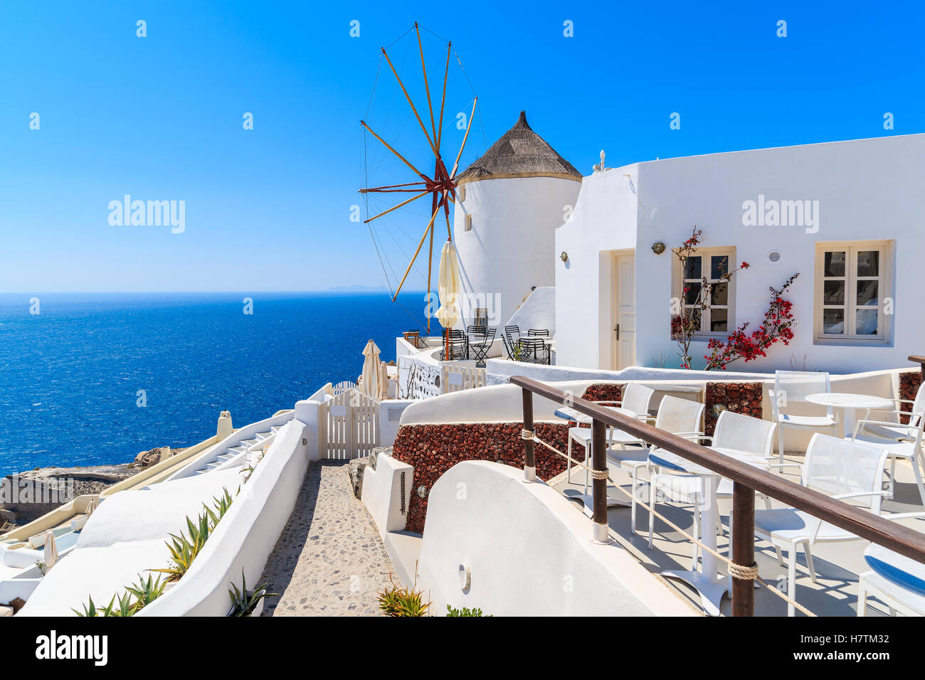 Typischen weißen Windmühle auf Straße von Dorf Oia mit Meer im Hintergrund, Santorin, Griechenland Stockfoto