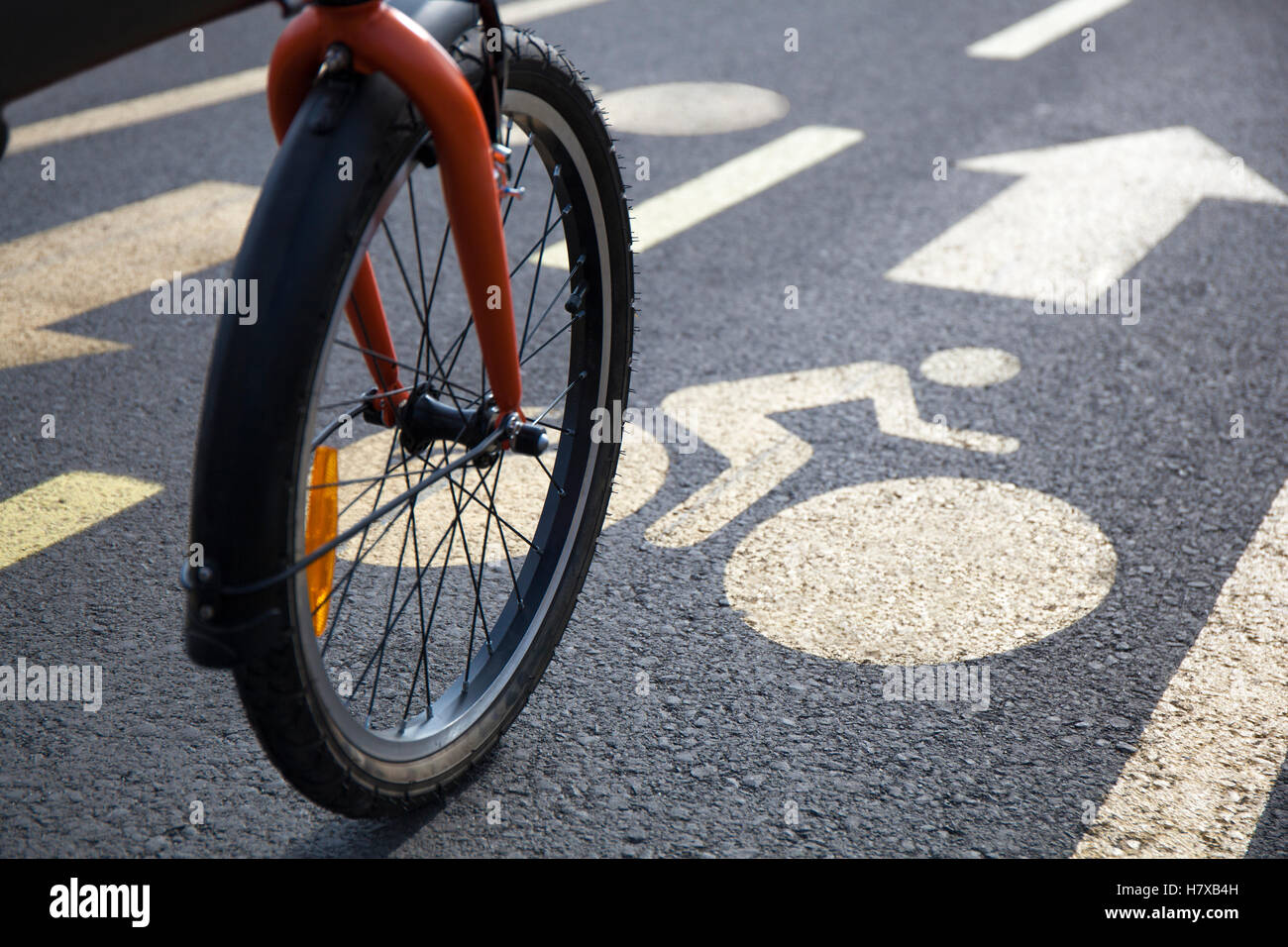 Fahrrad auf einem Radweg mit Schildern in der Stadt an einem sonnigen Tag verschieben. Stockfoto