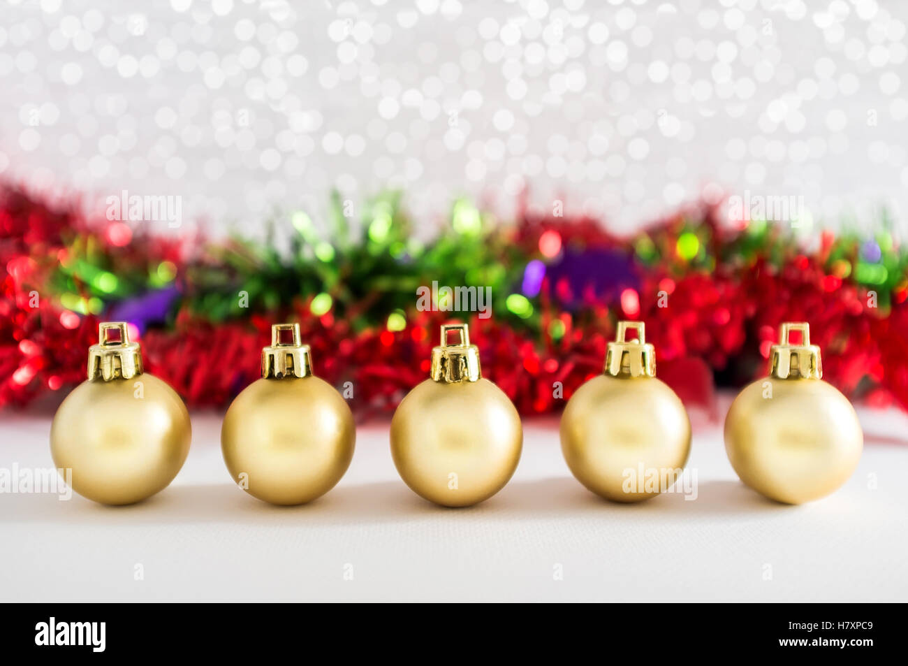 Goldene Kugeln und Weihnachtsschmuck mit Lichtern Schnee Winter Hintergrund. Platz für Kopie. Stockfoto
