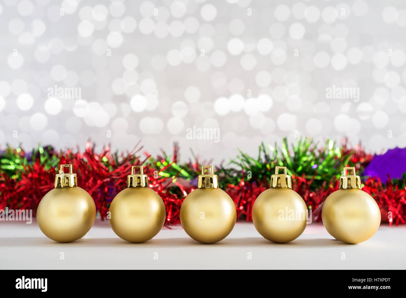 Goldene Kugeln und Weihnachtsschmuck mit Lichtern Schnee Winter Hintergrund. Platz für Kopie. Stockfoto