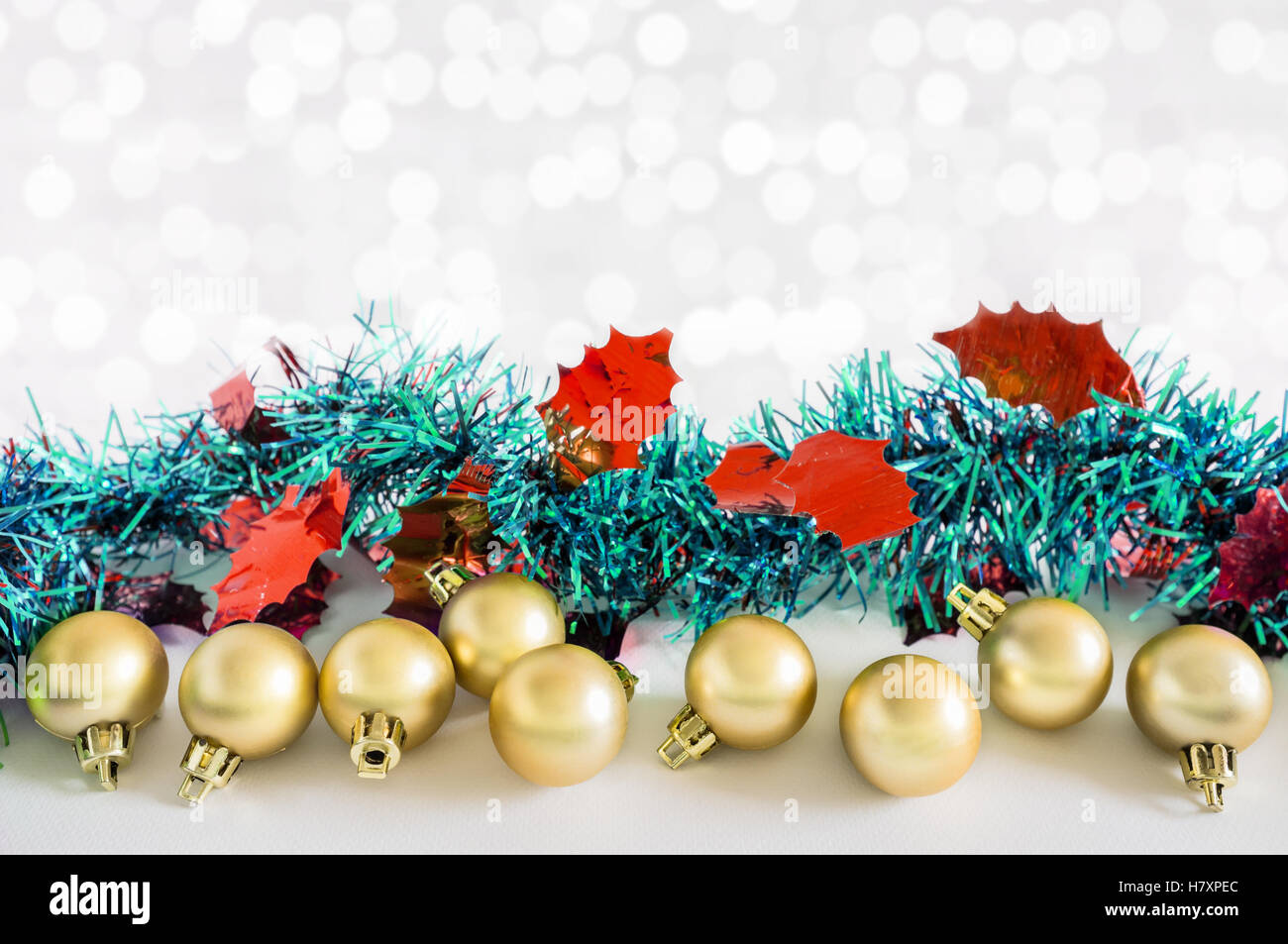 Goldene Kugeln und Weihnachtsschmuck mit Lichtern Schnee Winter Hintergrund. Platz für Kopie. Stockfoto