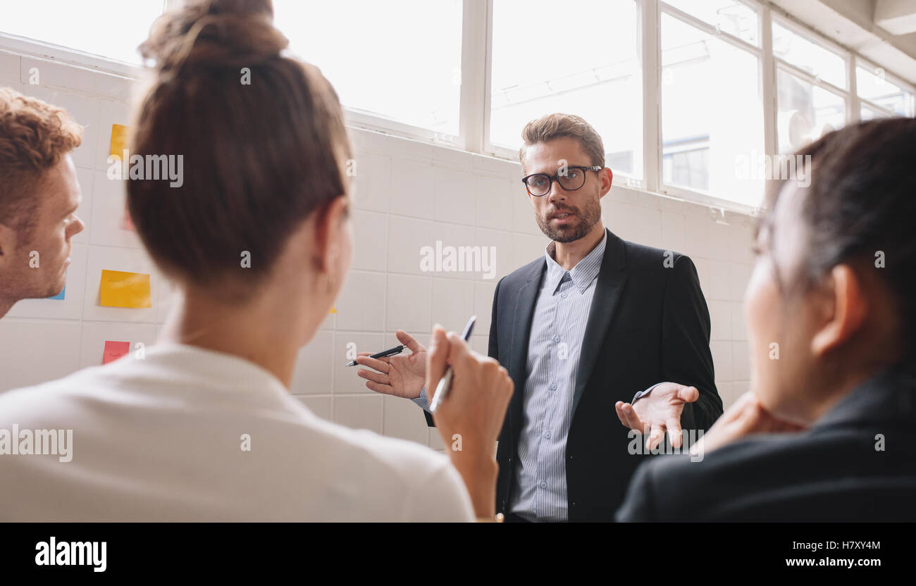 Junge Unternehmer im Gespräch mit Kollegen. Unternehmer diskutieren arbeiten im Tagungsraum. Stockfoto