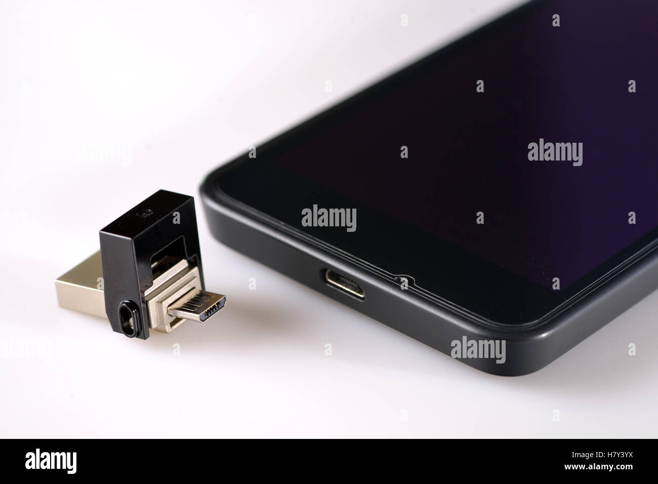 USB-Flash-Laufwerk und Smartphone auf weißen Tisch Stockfoto