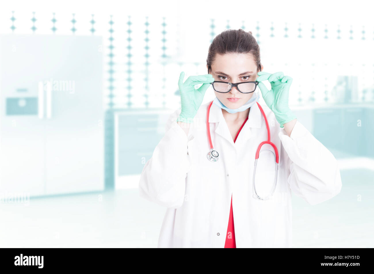 aPretty Frau Medic in medizinische Kleidung mit Stethoskop tragen Brillen bei der Arbeit mit Werbe-Bereich Stockfoto
