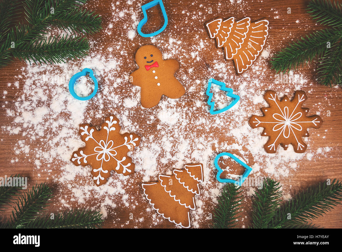 Weihnachten Plätzchen und Keksausstecher mit Zweig Tanne auf dem hölzernen Hintergrund. Stockfoto