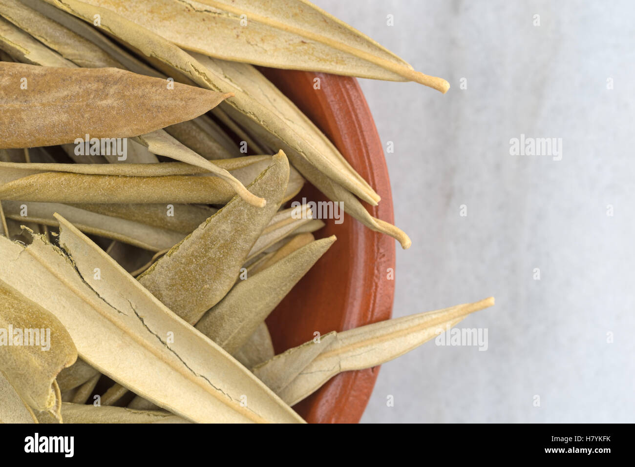 Enge Draufsicht des getrockneten Bio Olivenblätter in einer Schüssel auf einem grauen Marmortisch. Stockfoto