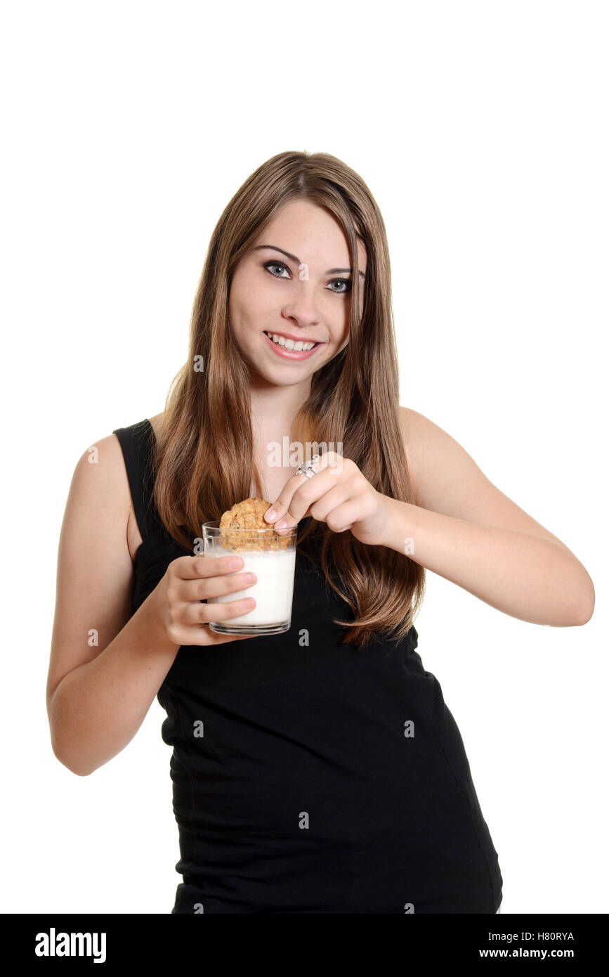 Teengirl dunking Haferflocken Cookies in Milch Stockfoto