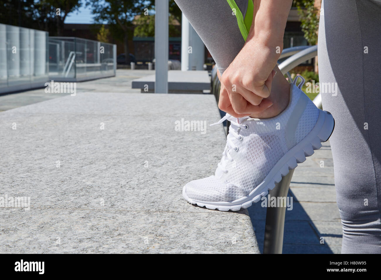 Frau binden Schnürsenkel vor dem Outdoor-Sport in der Stadt Stockfoto