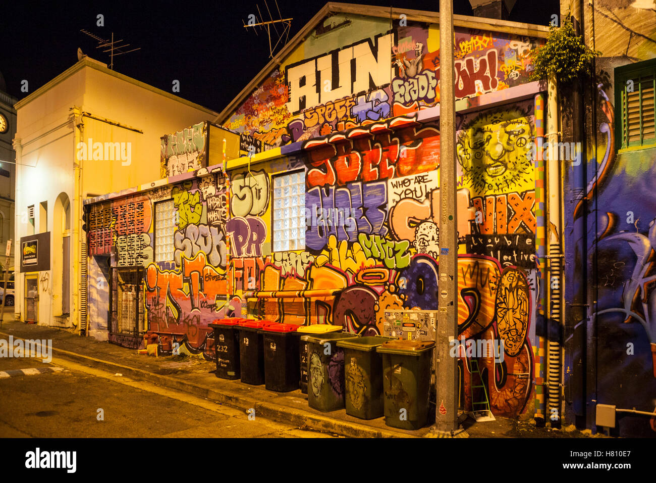 Bunte Graffiti an einem Gebäude in Townsville, Australien in der Nacht in Straßenlaterne. Stockfoto