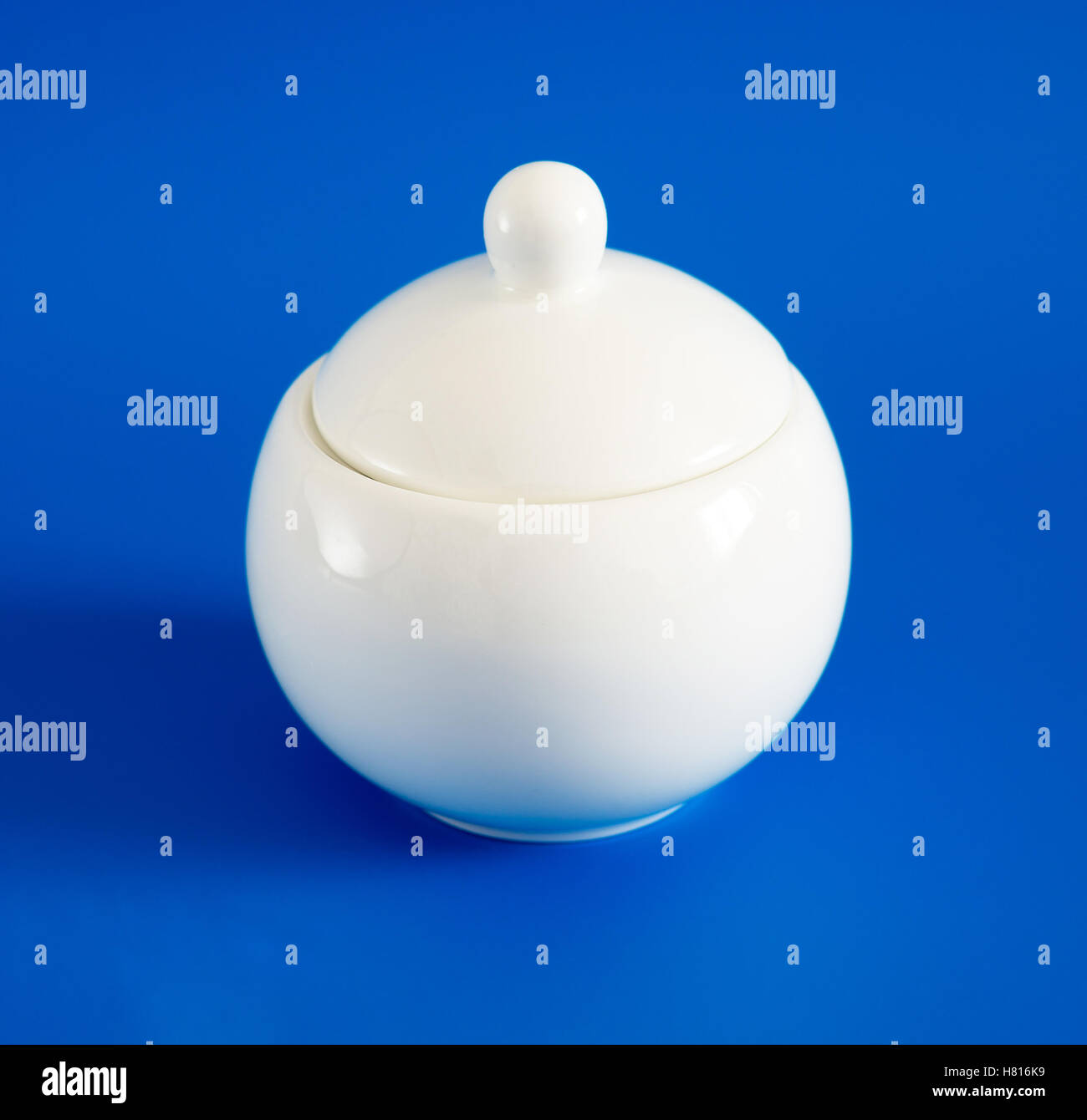 Weiße Zuckerdose mit Deckel auf blauem Hintergrund Stockfoto