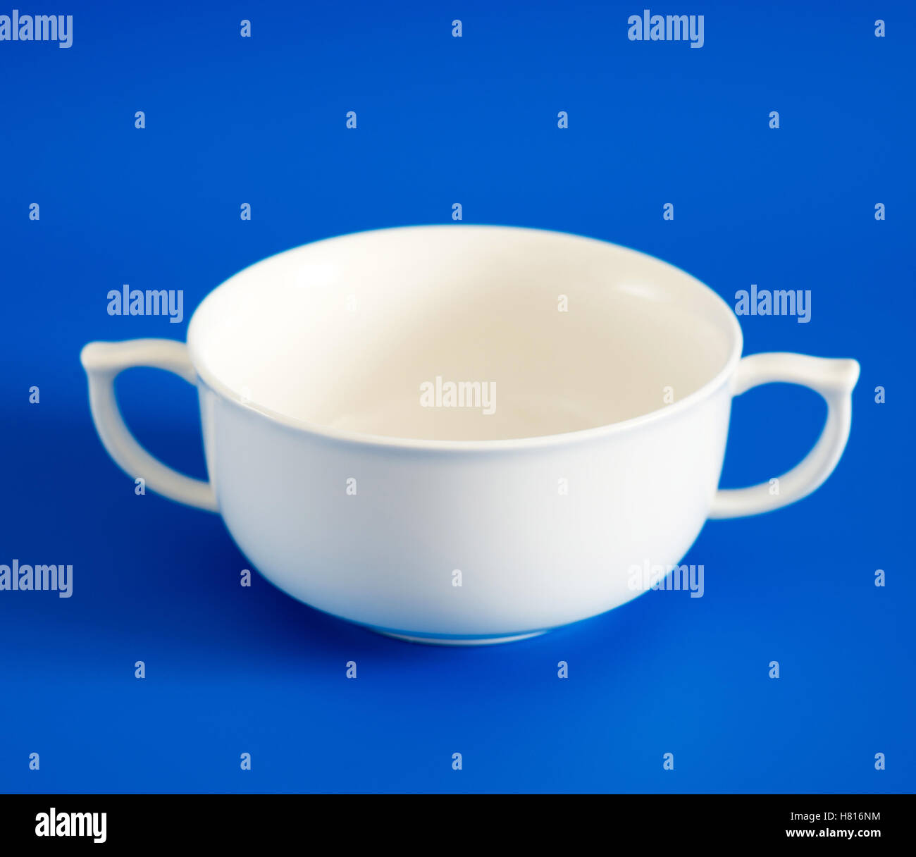 Weiße Tasse Suppe auf blauem Hintergrund Stockfoto