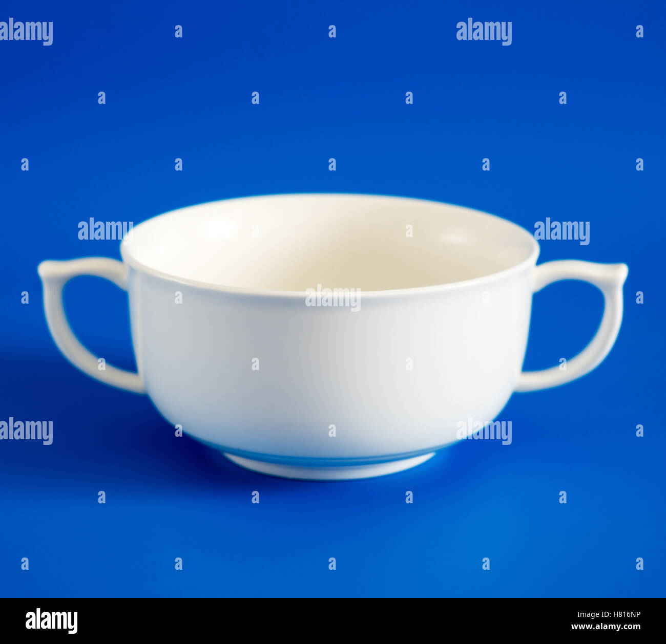 Weiße Tasse Suppe auf blauem Hintergrund Stockfoto