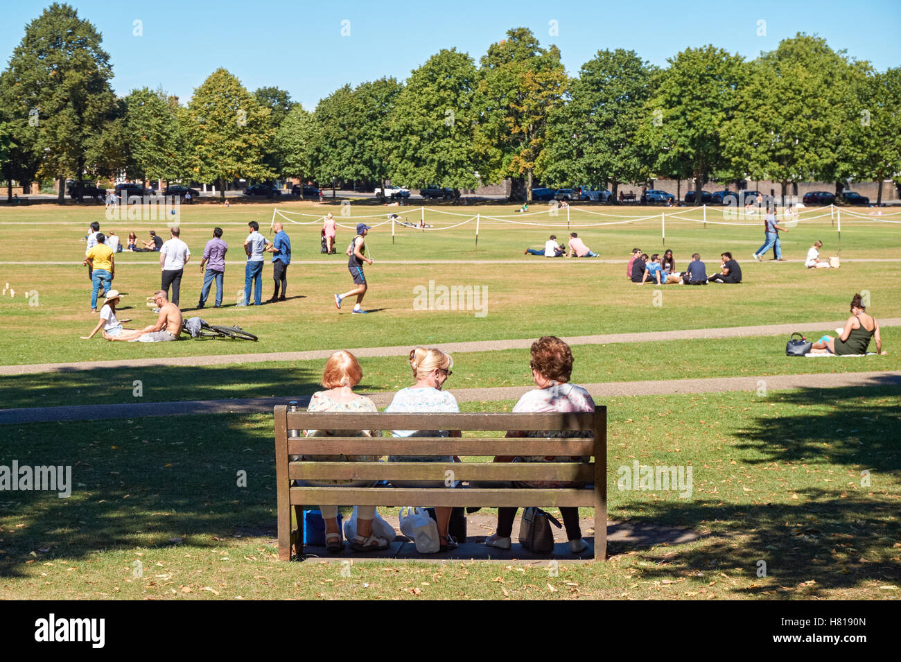 Menschen, die genießen sonnigen Wetter in Richmond Green Park, London England Vereinigtes Königreich UK Stockfoto