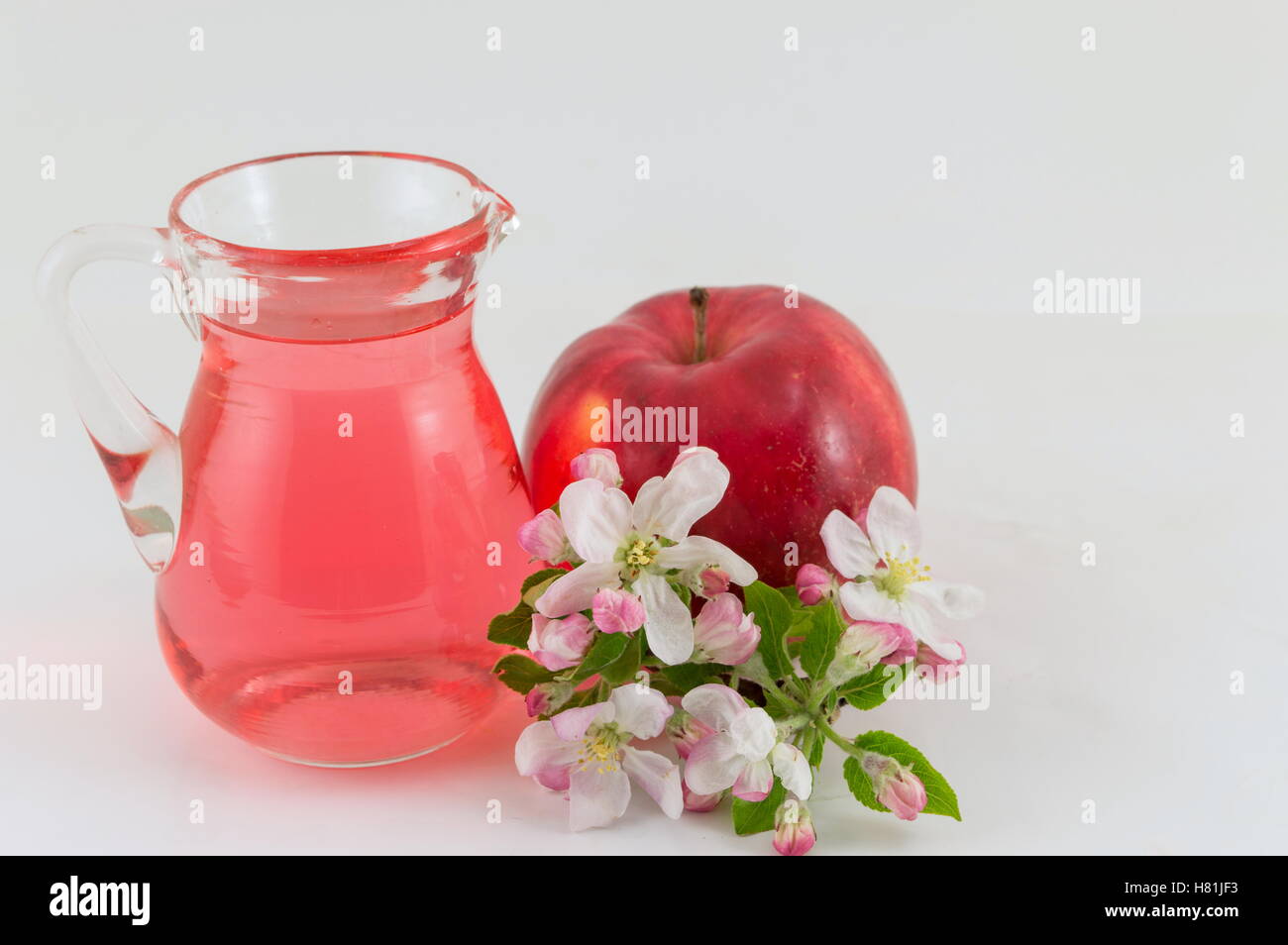 Roter Apfel und Apfelessig mit Blumen geschmückt Stockfoto
