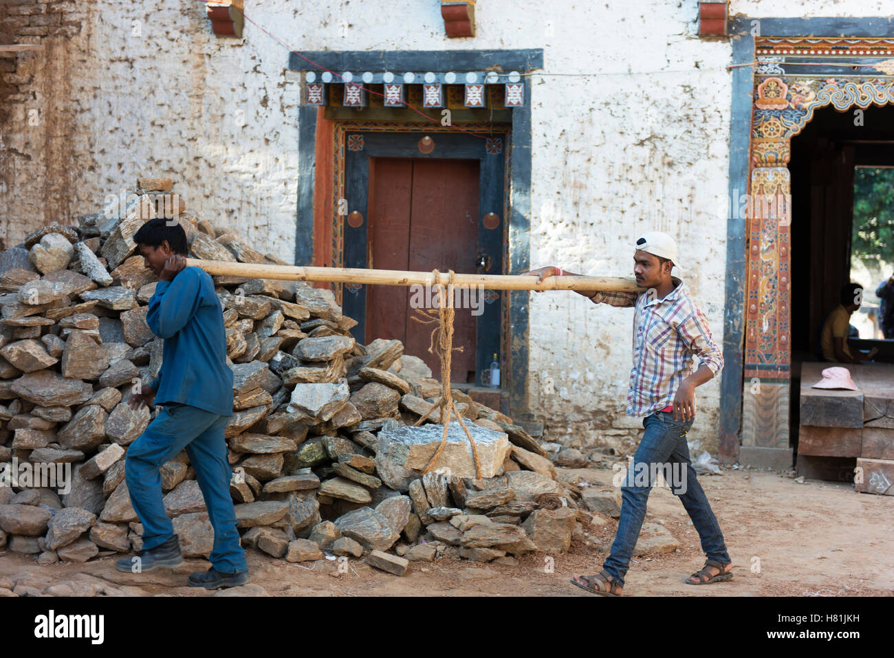Männer tragen Felsen für die Wiederherstellung von Trashigang Dzong nach Erdbebenschäden. Stockfoto