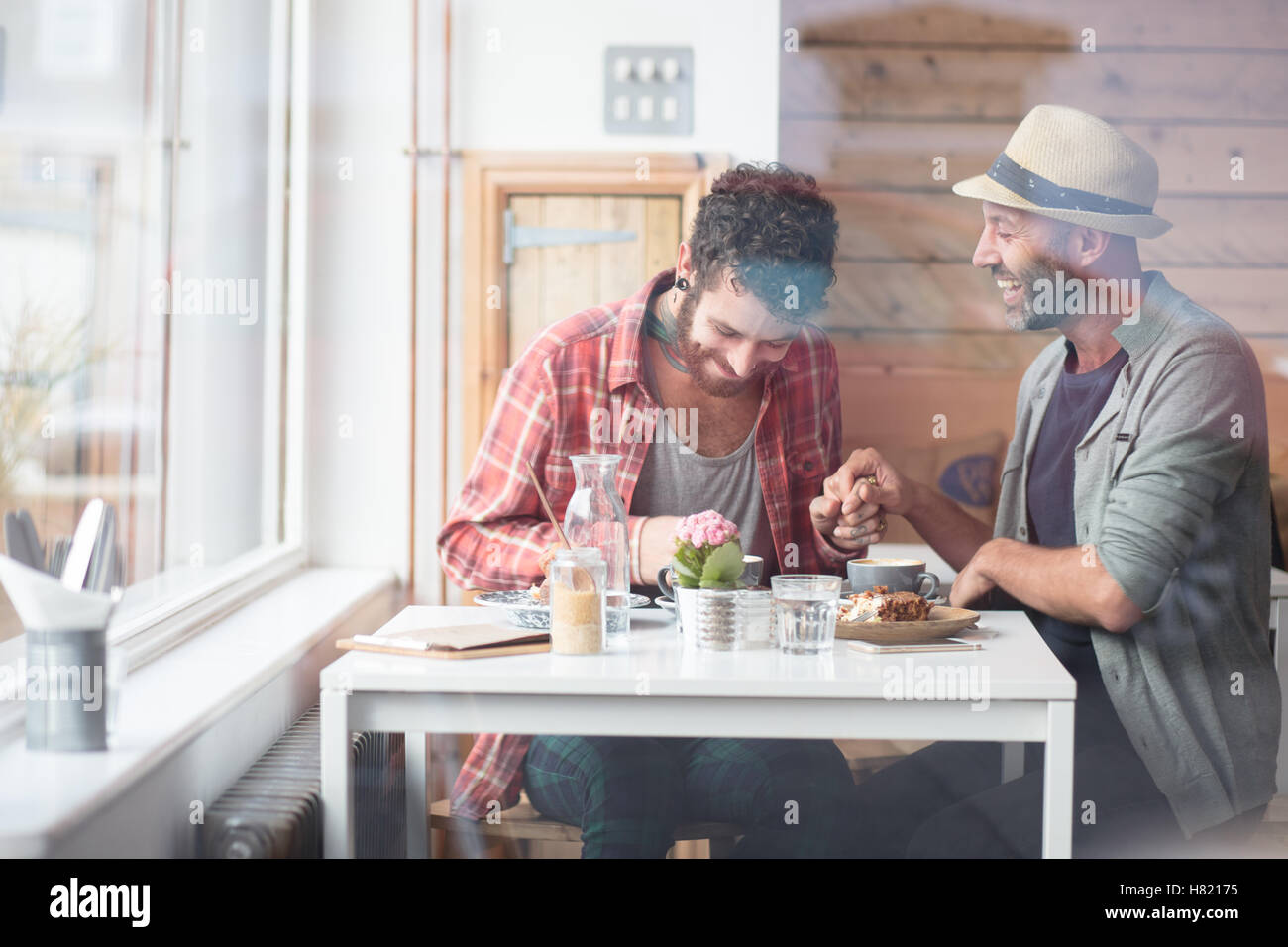 Gay paar saßen Hand in Hand im café Stockfoto