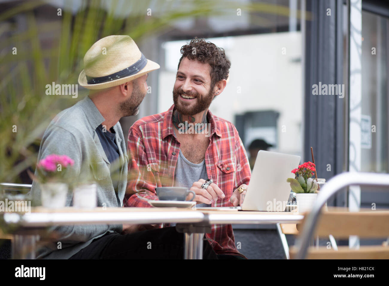 Gay paar saß Austausch Laptop im café Stockfoto