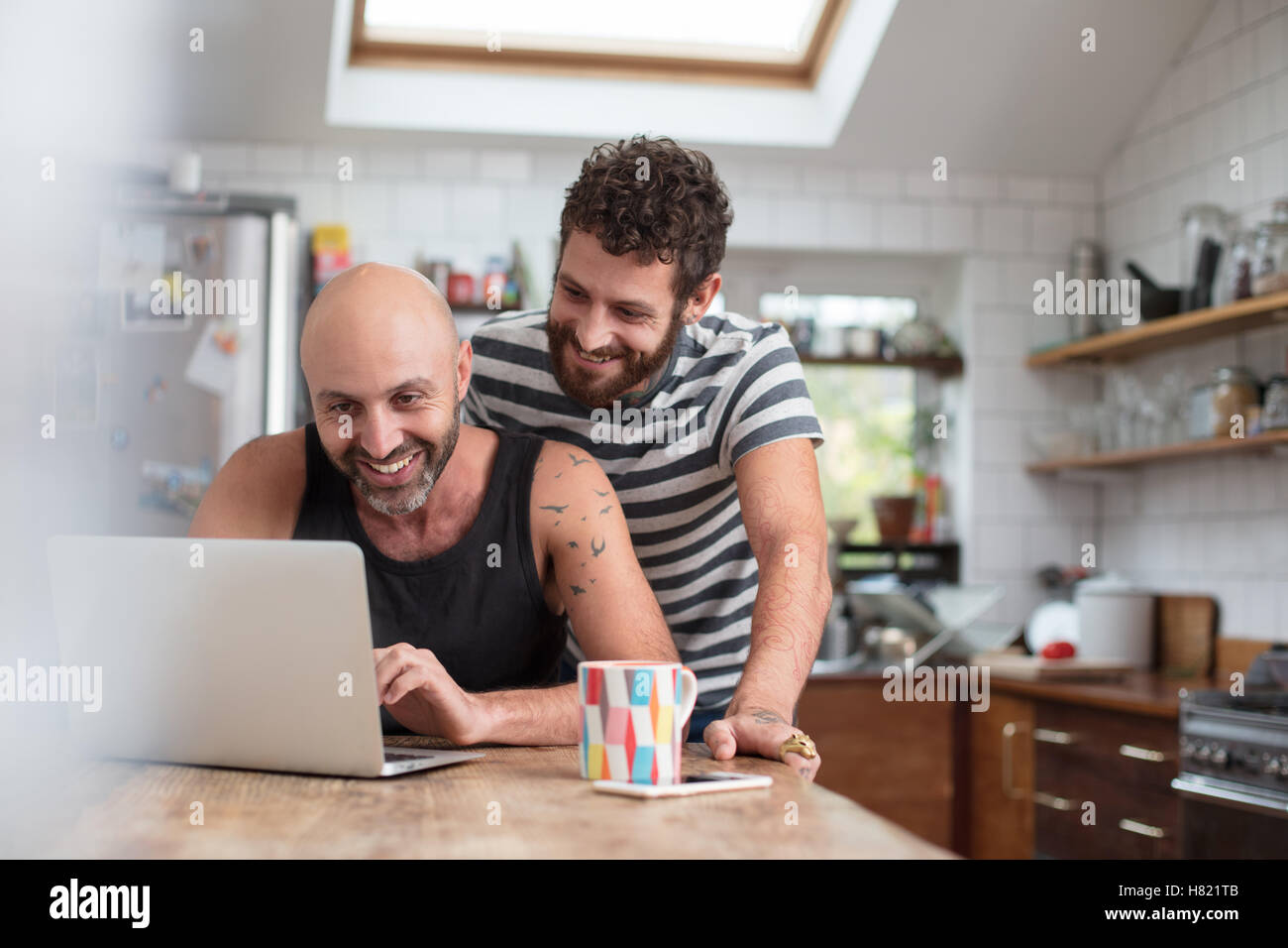 Gay paar mit Laptop in der Küche Stockfoto