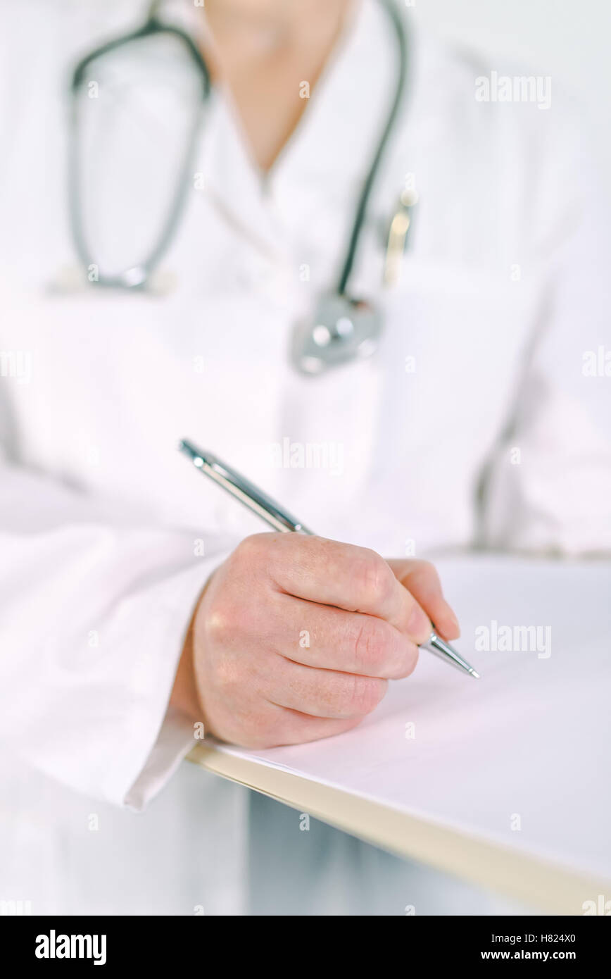 Ärztin in weißen Uniform auf Zwischenablage Papier Patienten medizinische Geschichte oder Medizin Rezept schreiben. Frau als Gesundheit sp Stockfoto