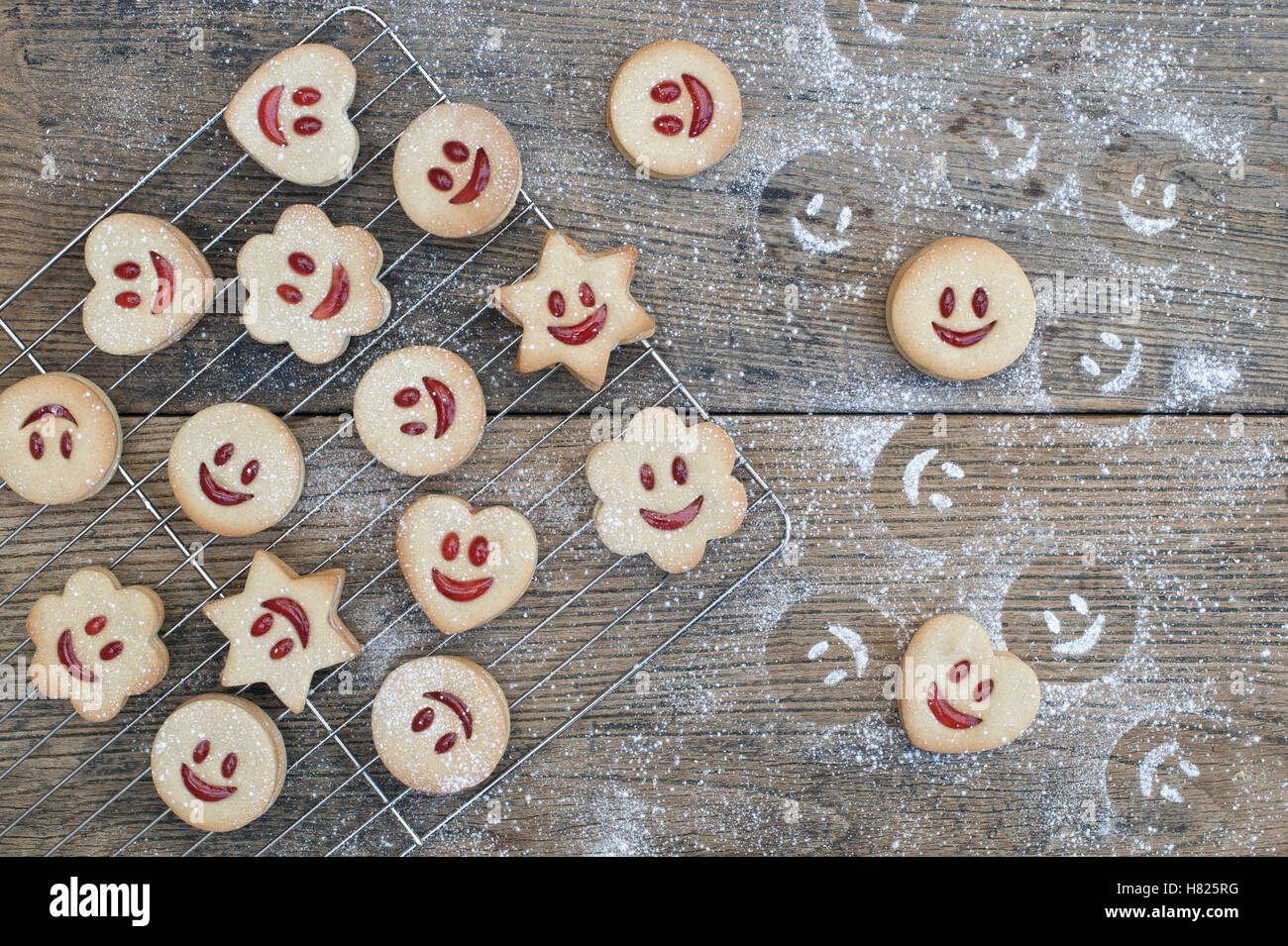 Hausgemachte Jammie Dodgers. Lächelndes Gesicht Kekse und Puderzucker Zucker Eindrücke auf Holz Stockfoto