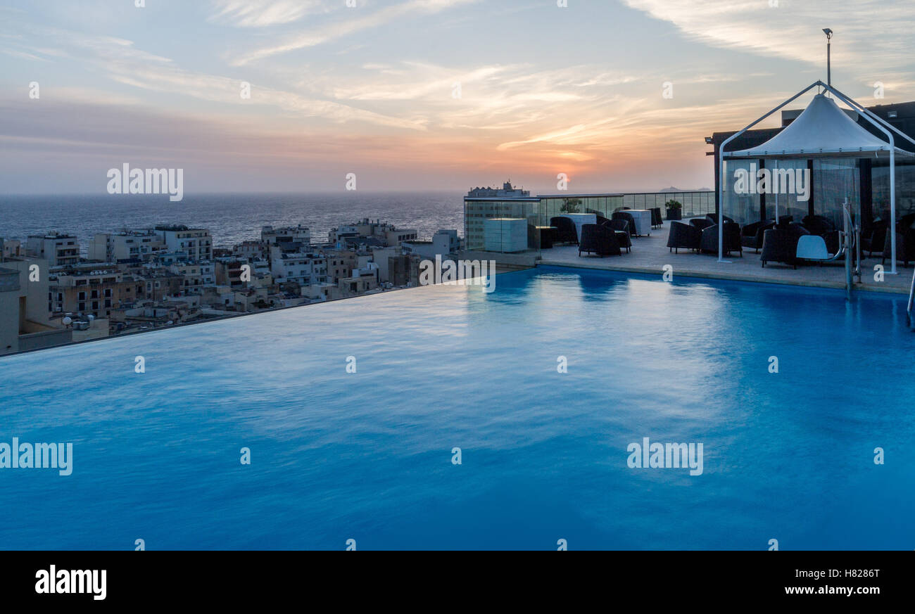 wunderschönen Sonnenaufgang in einer Malta Stadt auf einem hohen Gebäude mit Infinity-Swimmingpool Stockfoto