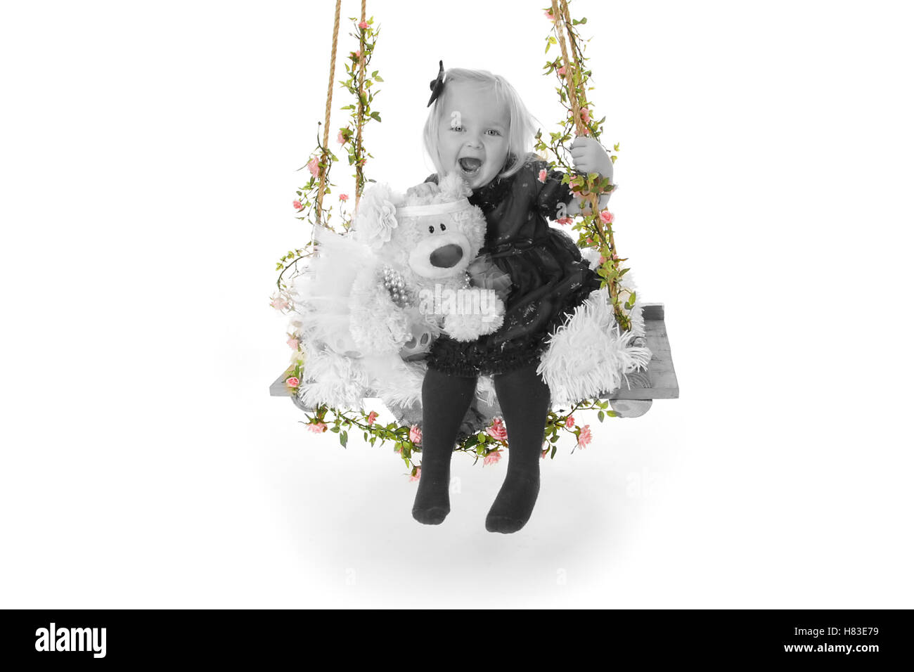Babymädchen auf Fotografie Studio Schaukel mit Blumen und teddy Stockfoto