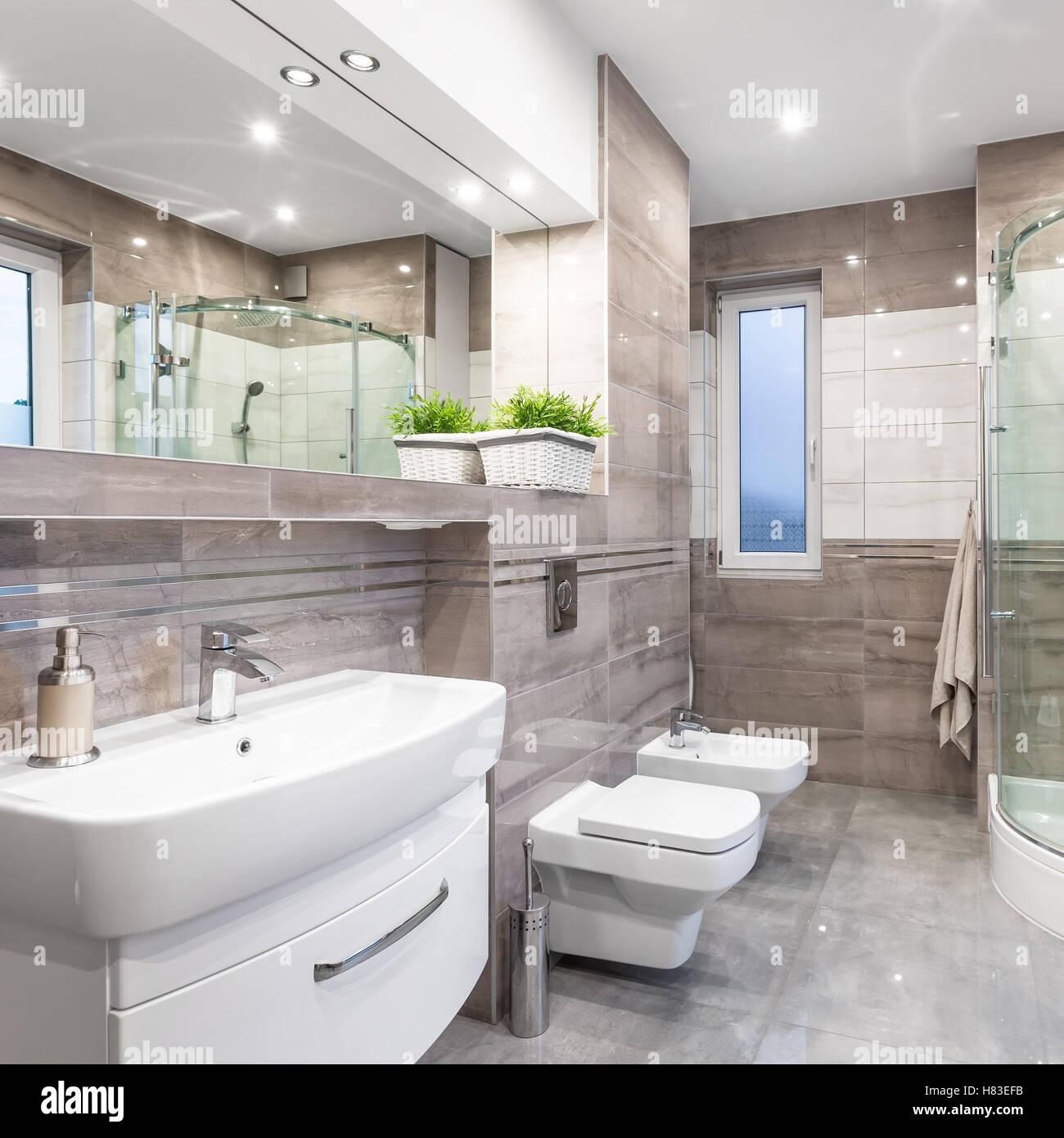 Neue Hochglanz-Bad in Beige mit Waschbecken, Spiegel, WC, Bidet und Dusche Stockfoto