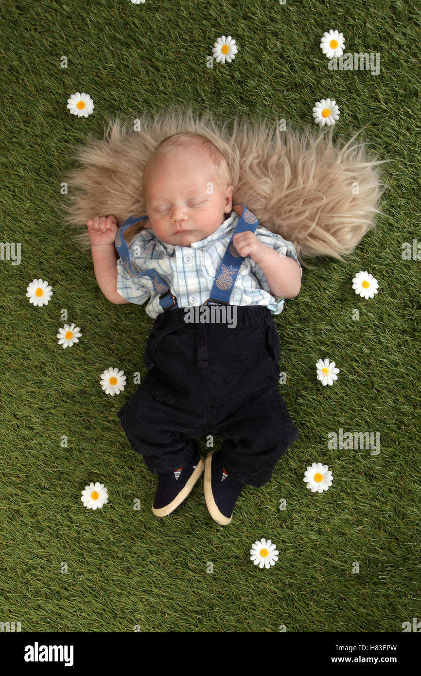 Neugeborenes Babyjungen schlafen auf dem Rasen im Garten Stockfoto