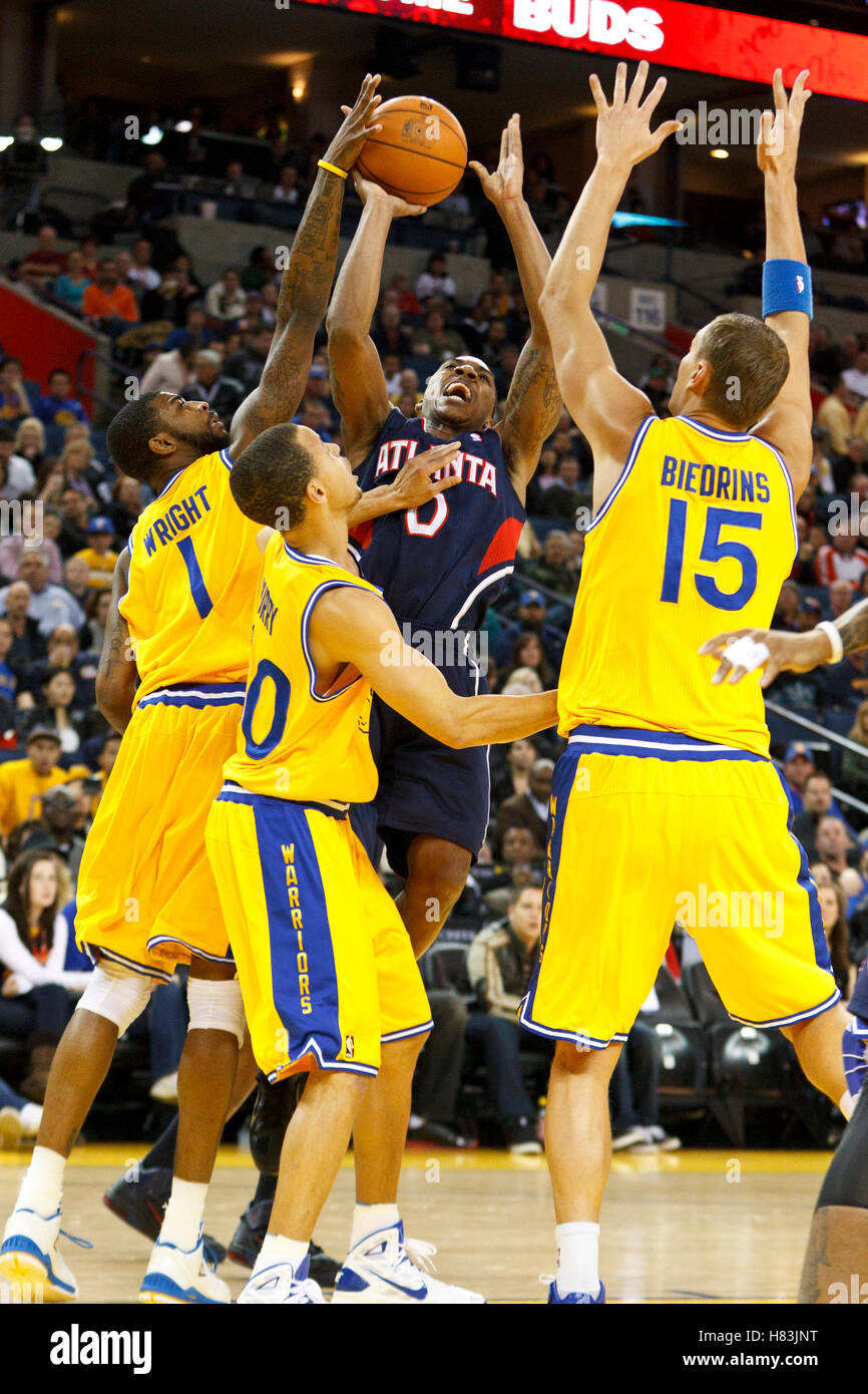 25. Februar 2011; Oakland, Kalifornien, USA;  Atlanta Hawks Guard Jeff Teague (0) wird durch die Golden State Warriors kleine vorwärts Dorell Wright (1) verteidigt, Stephen Curry (Mitte) zu schützen und zentriert Andris Biedrins (15) im ersten Quartal auf Oracle Arena. Auf Stockfoto