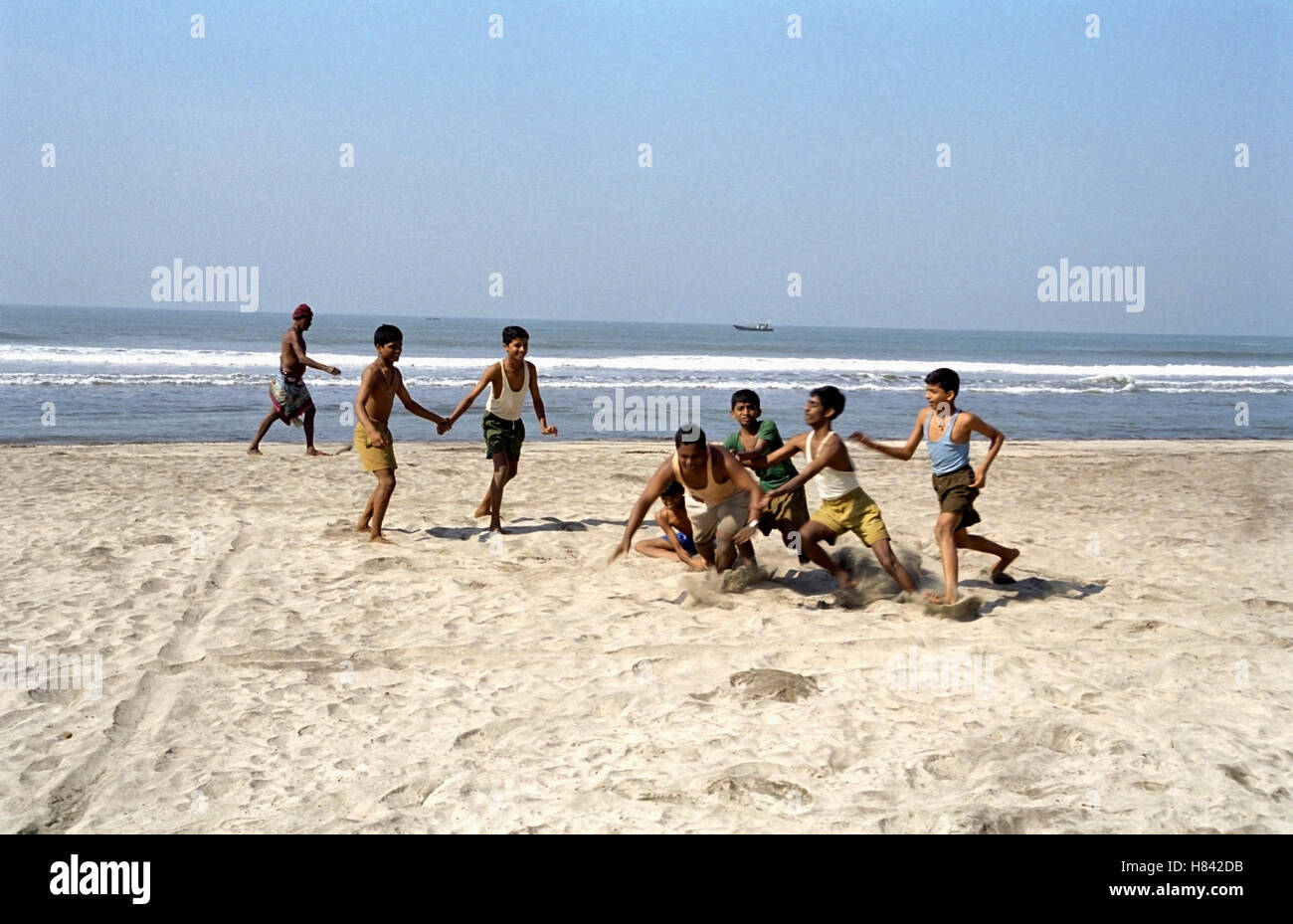 Kinder spielen Kabaddi am Meeresufer Stockfoto