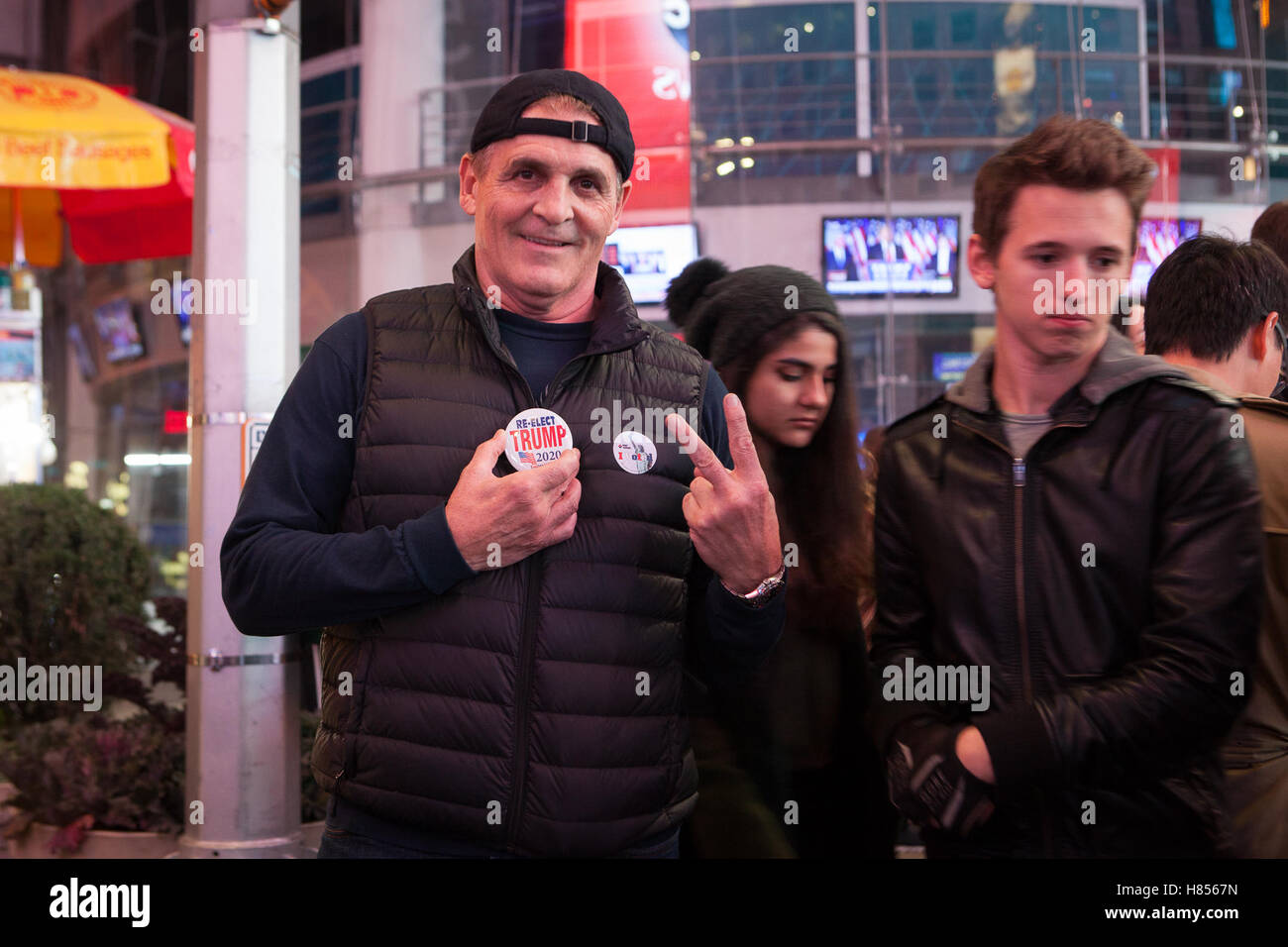 New York, NY, USA 9. November 2016. 02:50: ein Trumpf Anhänger (links) Gesten Sieg mit seinen Fingern beim Betrachten der Fotograf am Times Square. Foto: Alessandro Vecchi dpa Stockfoto