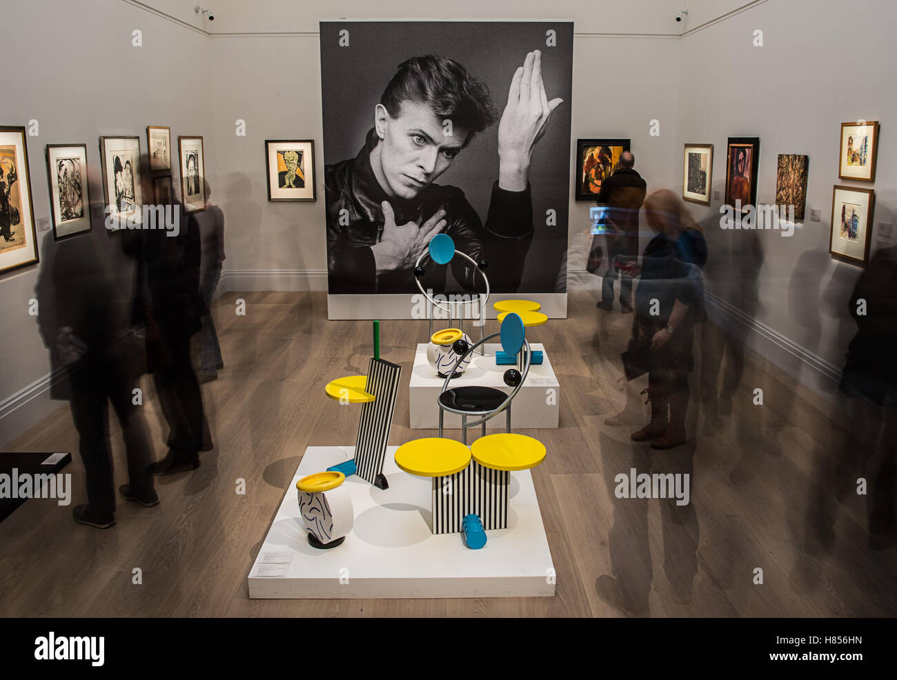 London, UK. 9. November 2016. David Bowie auf einem schwarz-weiß-Foto von Masayoshi Sukita, die auch auf dem Cover des Albums "Helden" in der Galerie des Auktionshauses Sotheby's in London, England, 9. November 2016. In der Mitte der Raum zwei Skulpturen von Michele de Luchi: "Paar der ersten Stühle" und "Flamingo Beistelltisch". Während einer zweiten Auktion wird Sothebys Versteigerung Werke aus der Privatsammlung Bowies 09 und 10. November 2016. Foto: Wolfram Kastl/Dpa/Alamy Live-Nachrichten Stockfoto