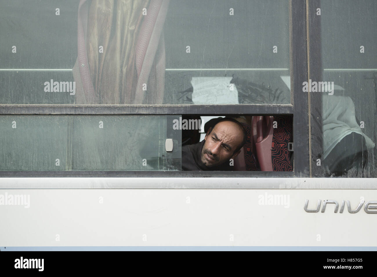 Mosul, Ninive, Irak. 10. November 2016. 11.10.2016. Mosul, Irak. Ein irakischer Mann sieht aus einem Busfenster für einen Freund als er und andere Familien entkommen Bereiche innerhalb der Stadt, dem Kämpfen zwischen irakischen Sicherheitskräften und militanten islamischen Staat stattfindet, warten von Gogjali Viertel der Stadt durch die irakische Armee evakuiert werden. Bildnachweis: ZUMA Press, Inc./Alamy Live-Nachrichten Stockfoto