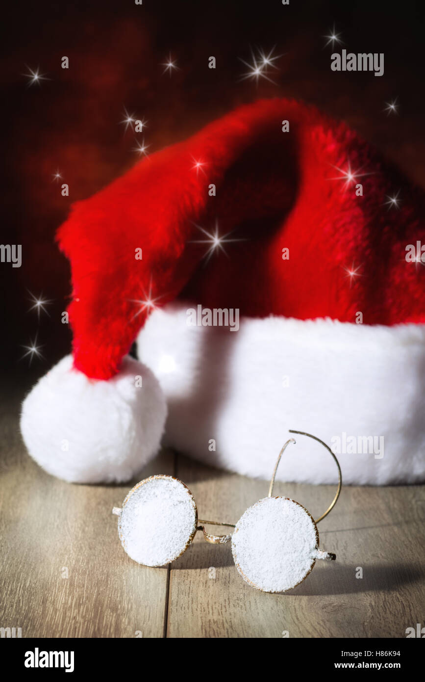 Santas Brille im Schnee mit seinem Hut bedeckt Stockfoto