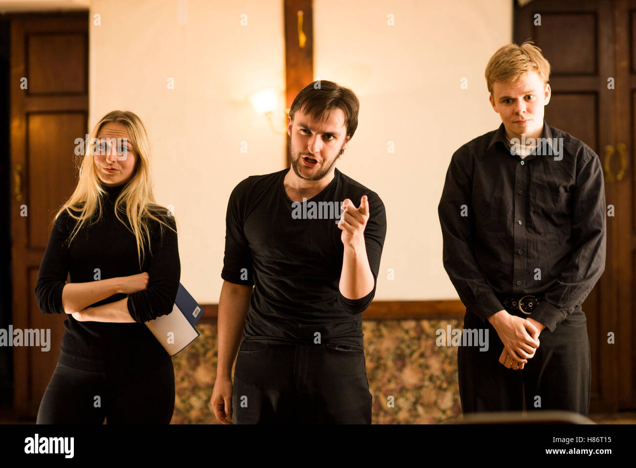 Drei junge Schauspieler tragen schlichte schwarzen Kostümen, die Durchführung Auszüge aus Shakespeares Theaterstücke und Poesie in einem kleinen Theaterraum über einem Pub in Aberystwyth Wales UK Stockfoto