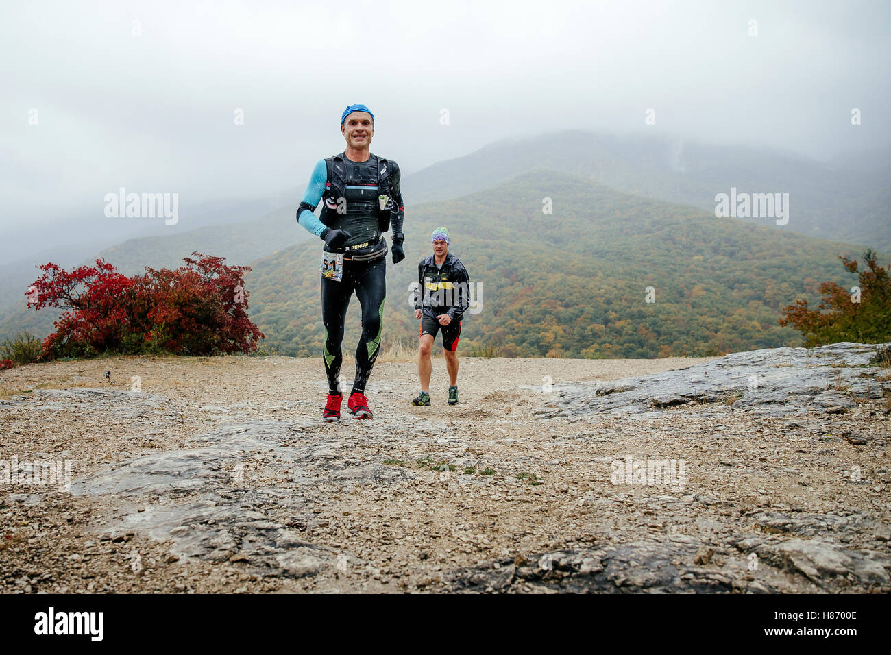 zwei Läufer Männer mittleren Alters im Regen auf einem Bergweg in Crimea Bergmarathon Stockfoto