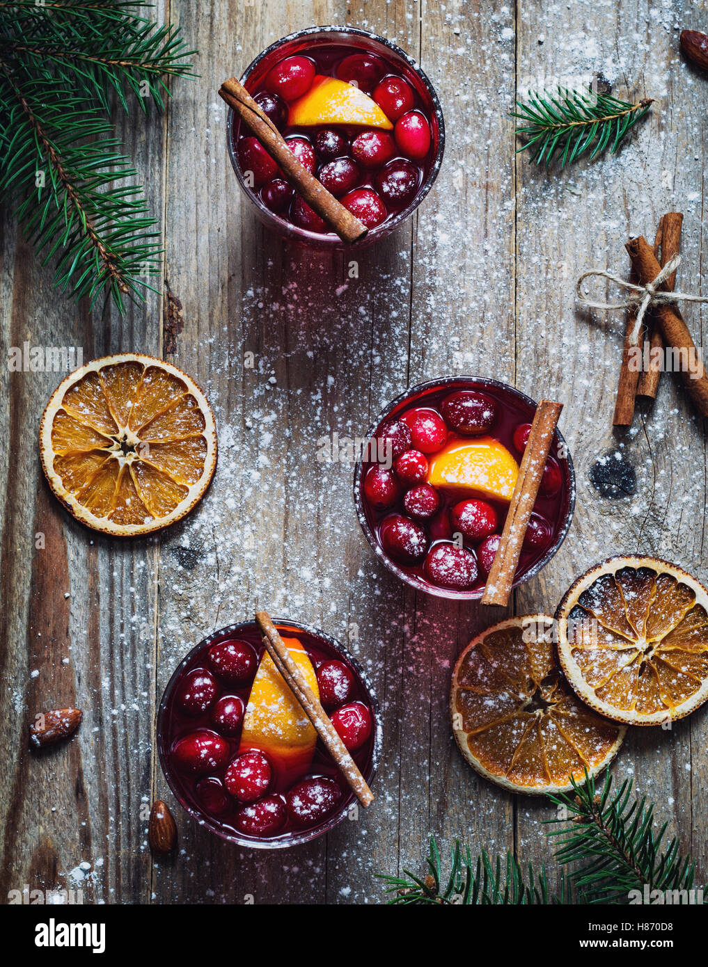 Würzigen Glühwein mit Preiselbeeren, Zimt und Orange in Gläsern auf Holztisch. Ansicht von oben Stockfoto