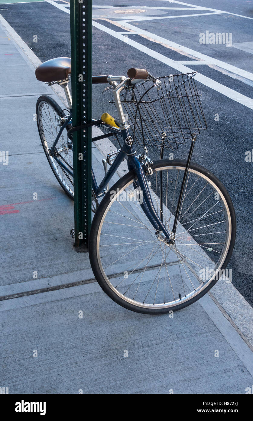 Ein Linus Steel Frame 10-fach Frau Fahrrad gebunden an ein Schild auf einer Straße in New York City Stockfoto